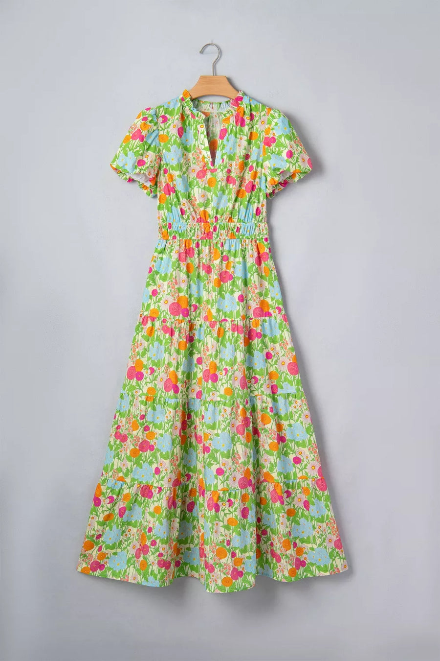 Maxi dress with ruffled neckline, short sleeves, tiered skirt, and vibrant floral print on cotton.