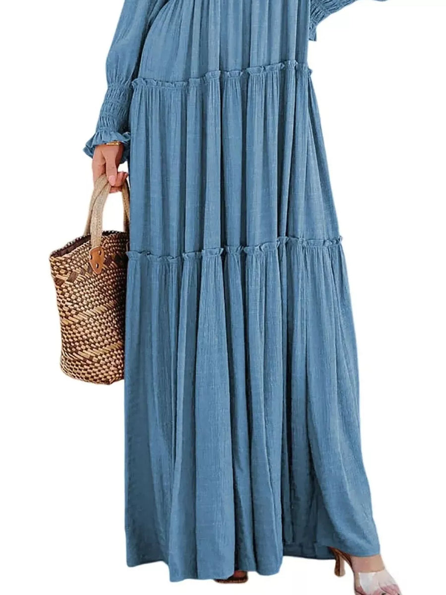 Blue smocked v-neck tiered maxi dress with ruffled details and long sleeves.
