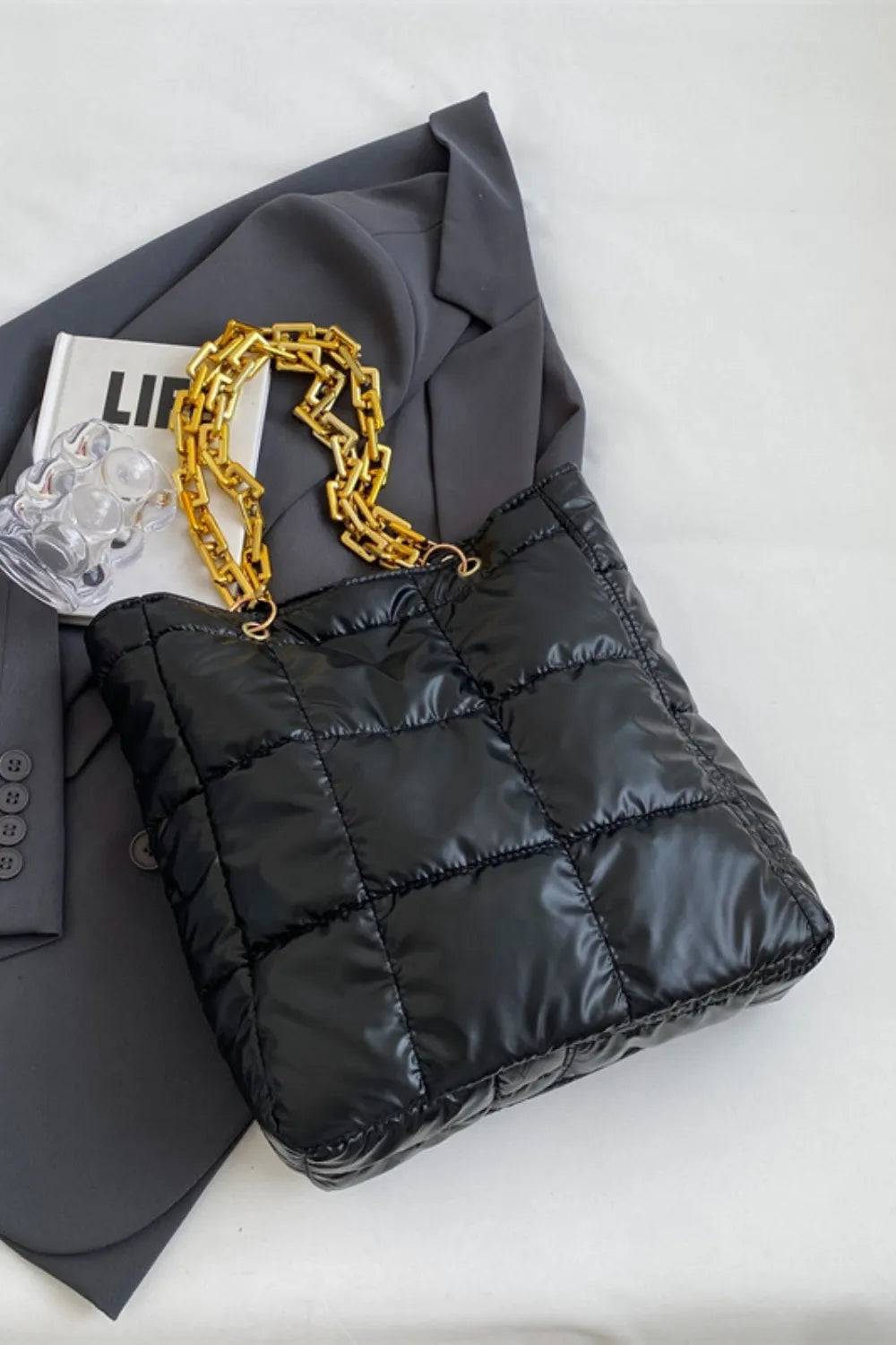 Black quilted nylon tote bag with gold chain handle