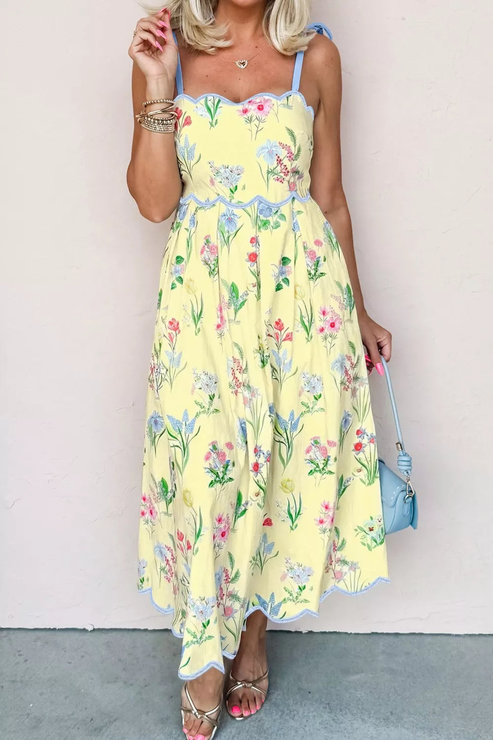 Yellow floral midi dress with bow straps, scalloped trim, and a-line cut.