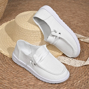 White linen-blend boat shoes with contrast sole and tie detail.