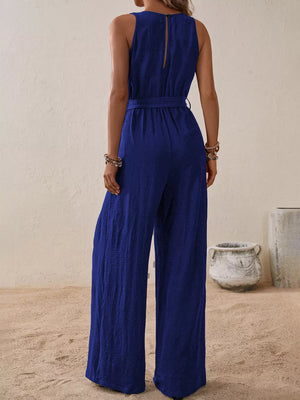 Royal blue V-neck tie-waist wide-leg romper with textured fabric and button closure at back neck.