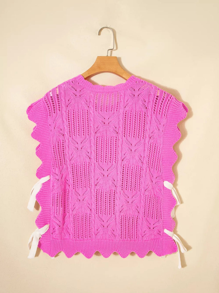 Chic openwork knit sweater vest in bright pink with cable knit pattern and adjustable white side ties.