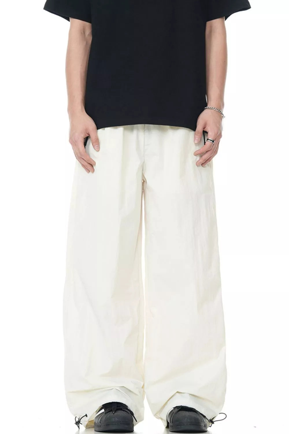 Men's cream wide-leg sweatpants with a flowing fit and drawstring cuffs.