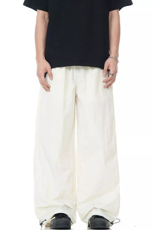 Men's cream wide-leg sweatpants with a flowing fit and drawstring cuffs.