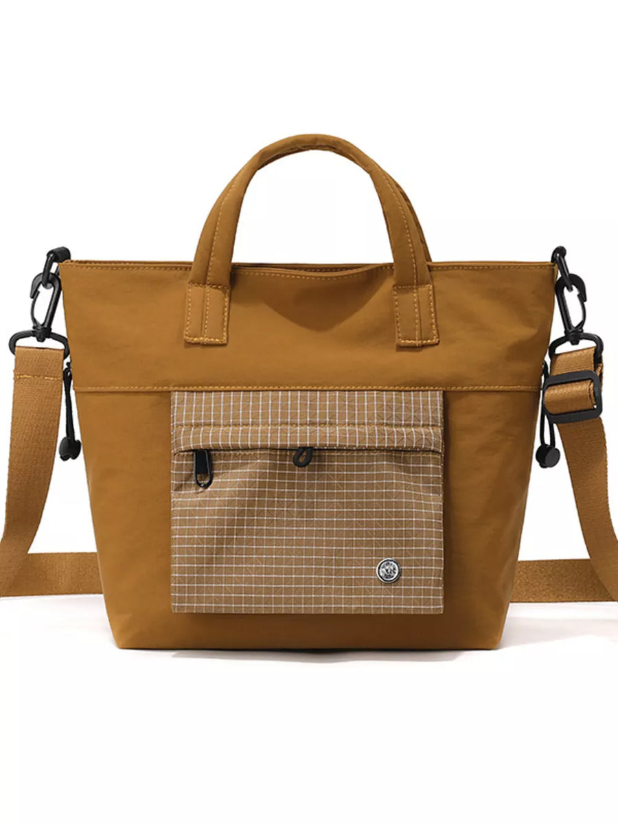 Brown nylon crossbody bag with plaid pocket detail and adjustable strap.