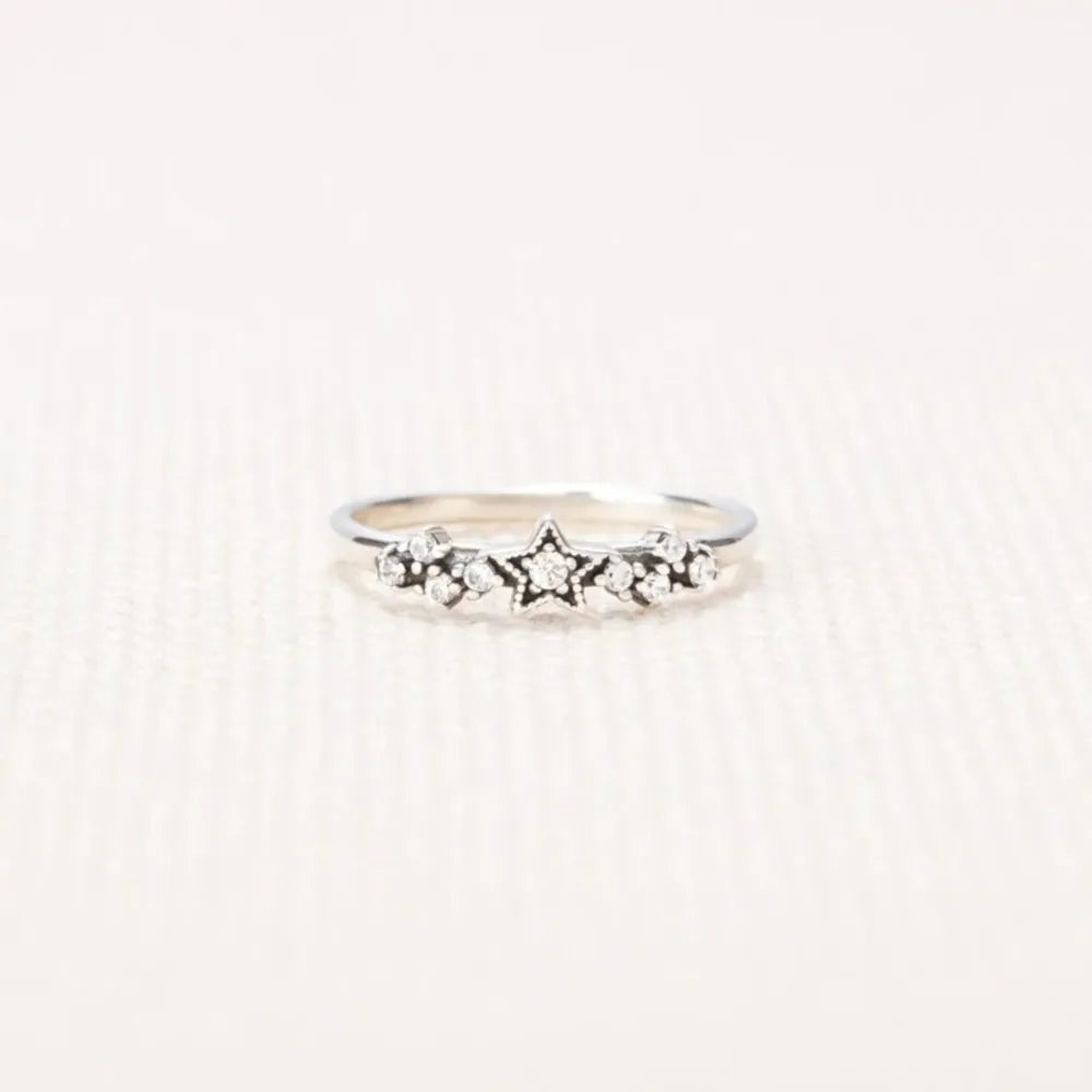 Silver band ring with a celestial cluster of stars and small stones.