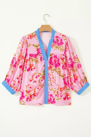 Pink floral v-neck blouse with blue striped accent and cuffs