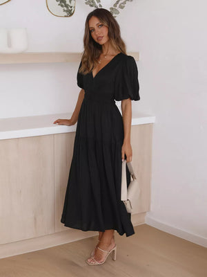 Black midi dress with puff sleeves, V-neck, and tiered skirt.
