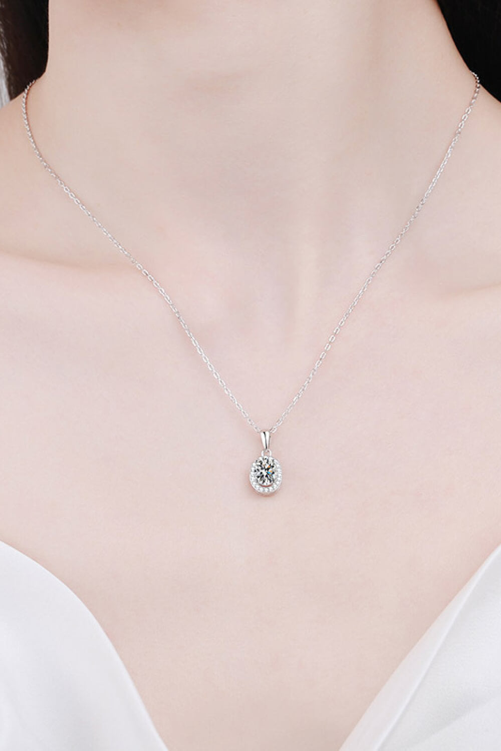 Silver halo moissanite pendant necklace on a delicate chain, crafted from 925 sterling silver.