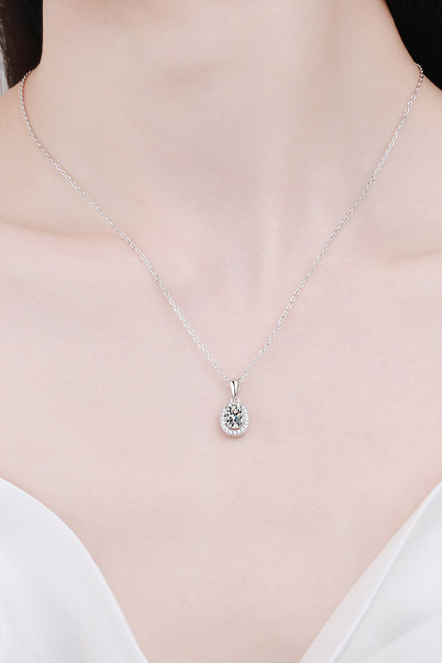 Silver halo moissanite pendant necklace on a delicate chain, crafted from 925 sterling silver.
