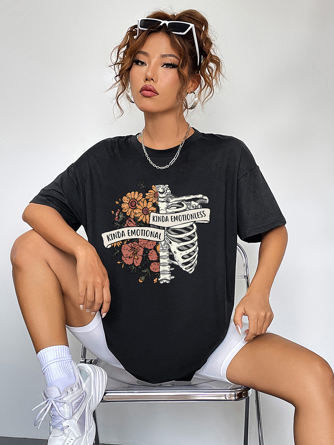 Black graphic t-shirt with skeleton and floral print, featuring text.
