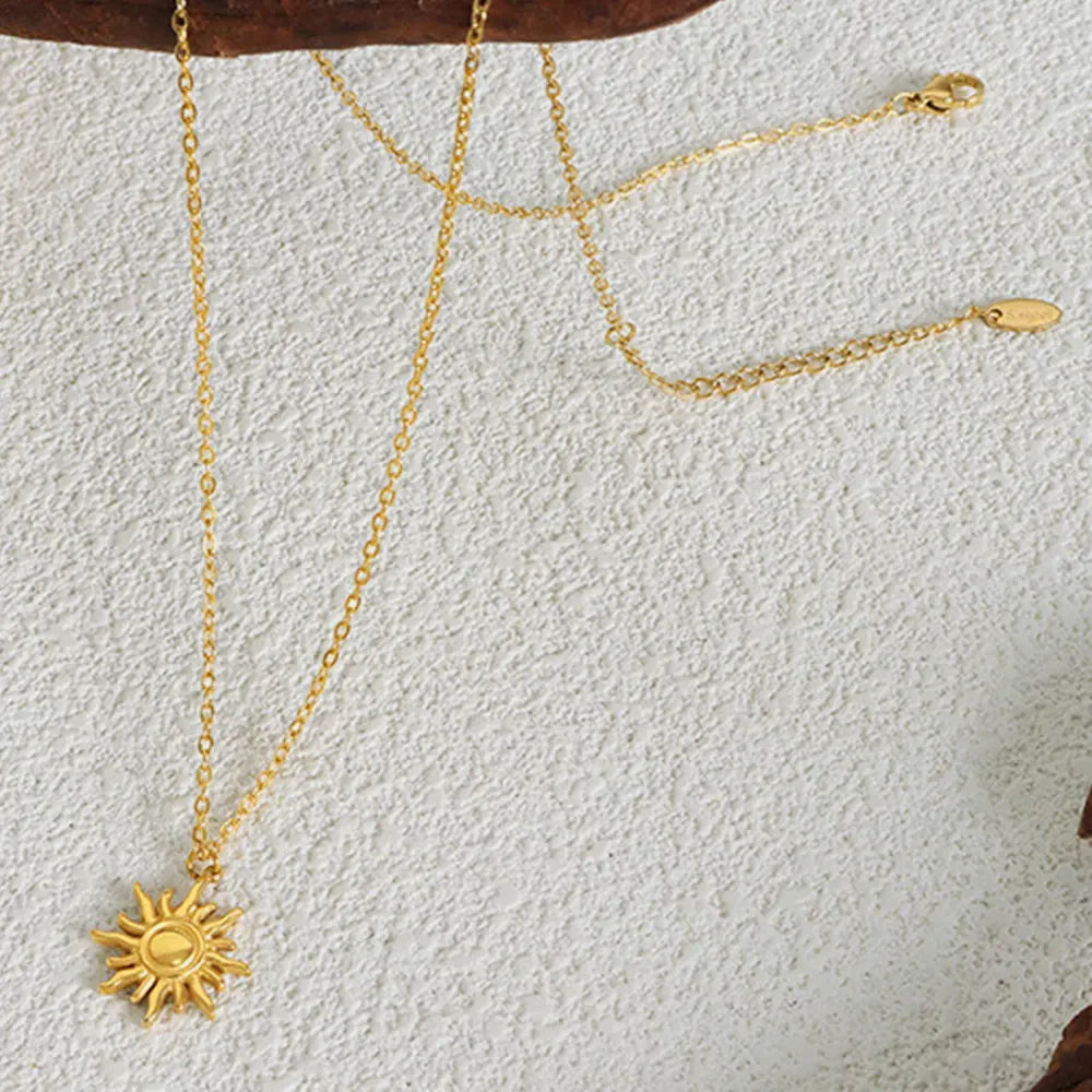 Gold sunburst pendant necklace with adjustable chain, 18K gold-plated.