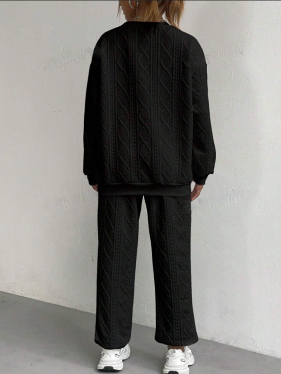 Black cable knit loungewear set with crewneck sweatshirt and wide-leg pants.