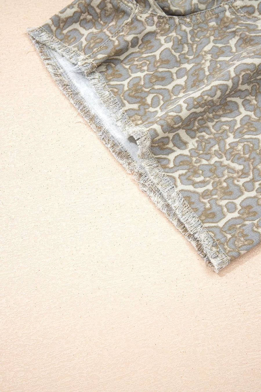 Denim shorts with leopard print and frayed hem detail.