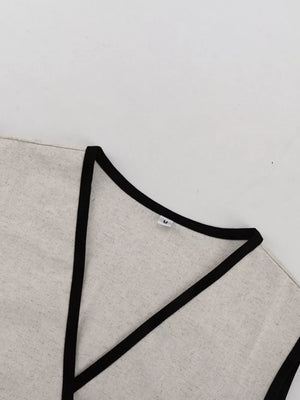 Linen blend vest in natural with black trim and V-neckline.