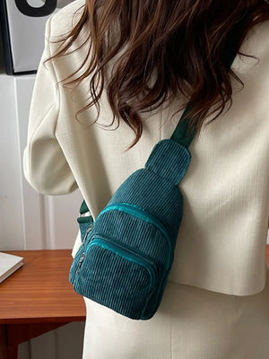 Deep Teal corduroy sling bag with zip pockets worn crossbody.