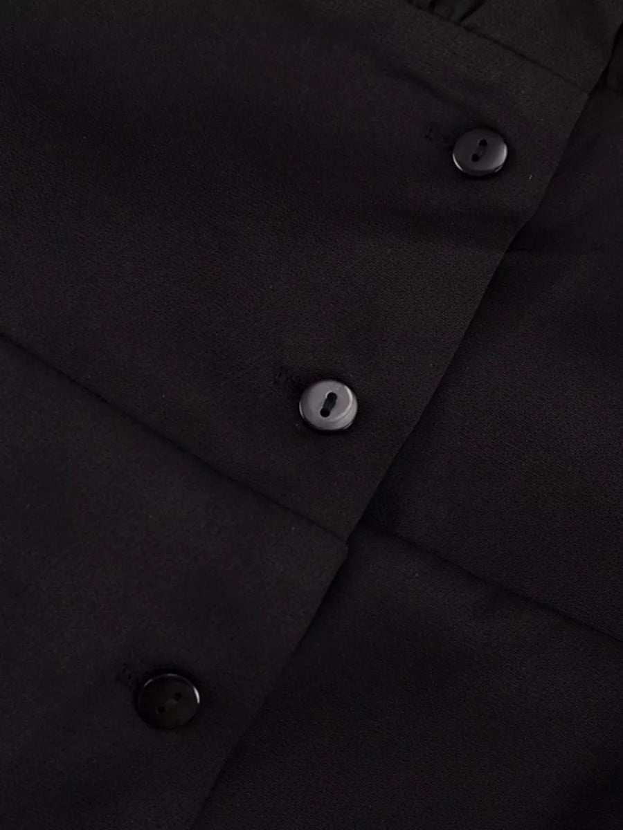 Black button-up blouse with textured fabric and dark buttons.