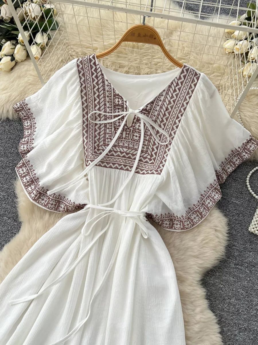 White bohemian maxi dress with V-neck, embroidered details and tie waist.
