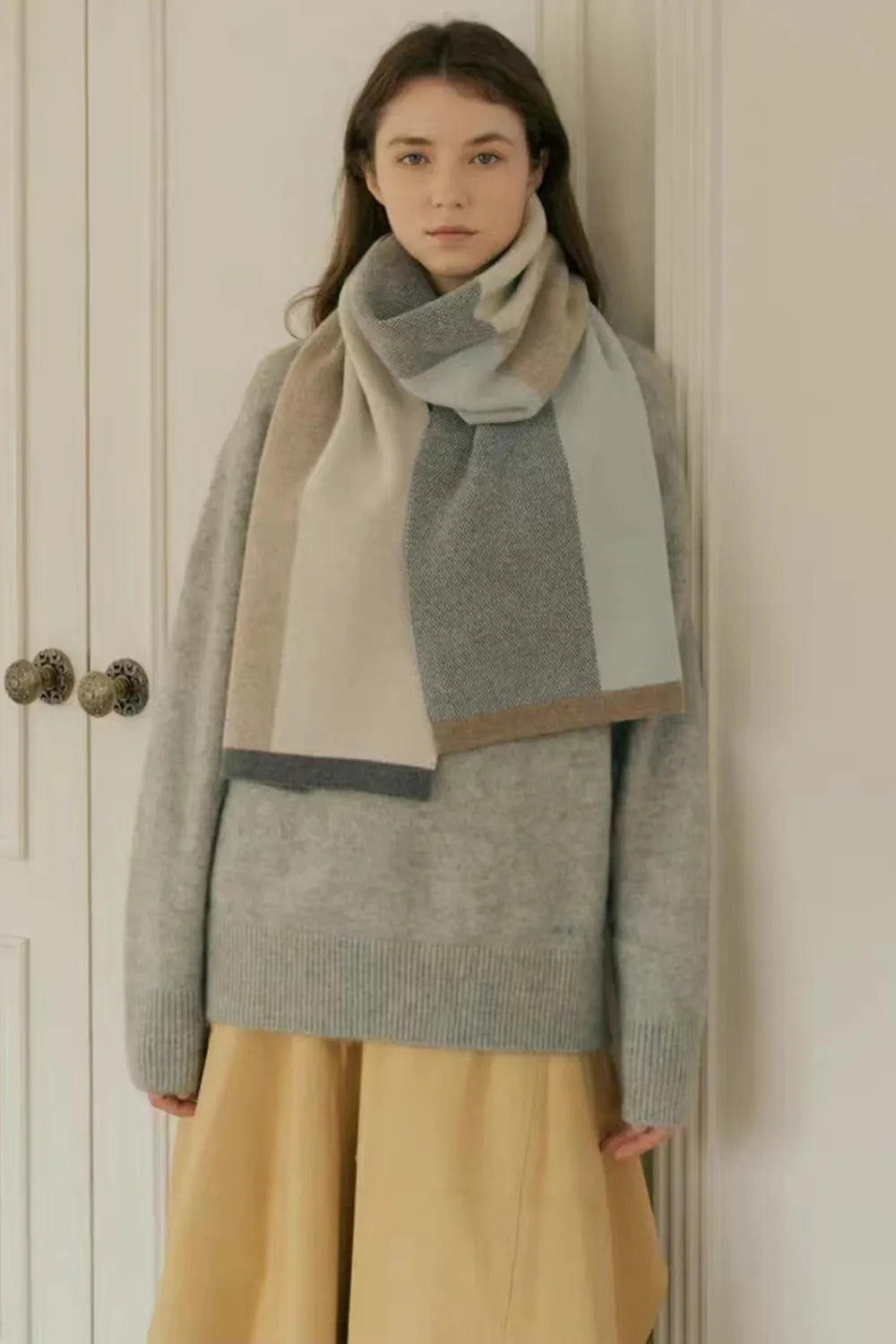 Colorblock merino wool scarf in sage, beige, and camel with a textured weave.