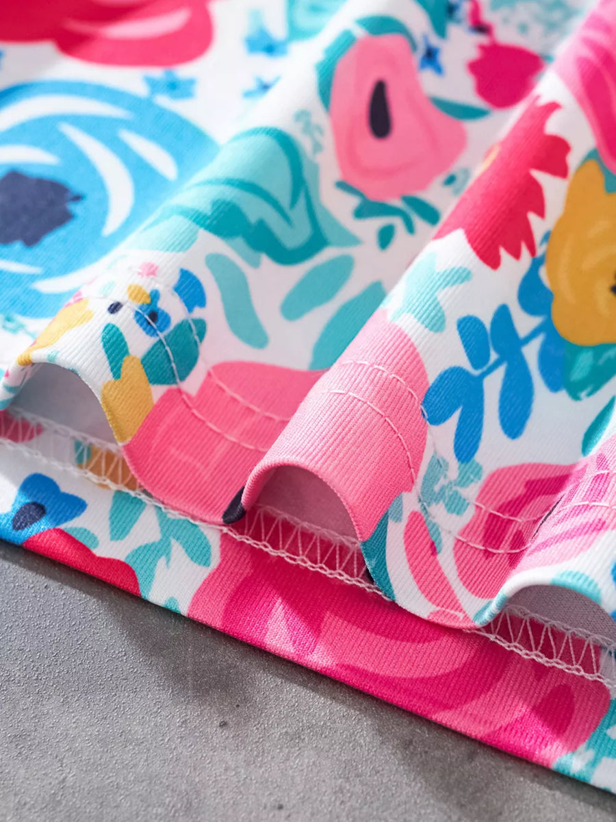 Top with vibrant floral print, pink trim, and white stitching.