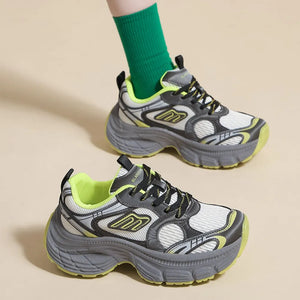 Chunky retro runner sneakers in white with grey and neon yellow accents, featuring a thick sole.