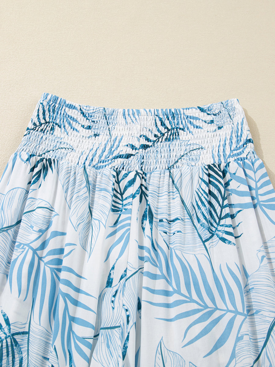 Tropical leaf print wide leg pants with smocked waist in white and blue cotton.