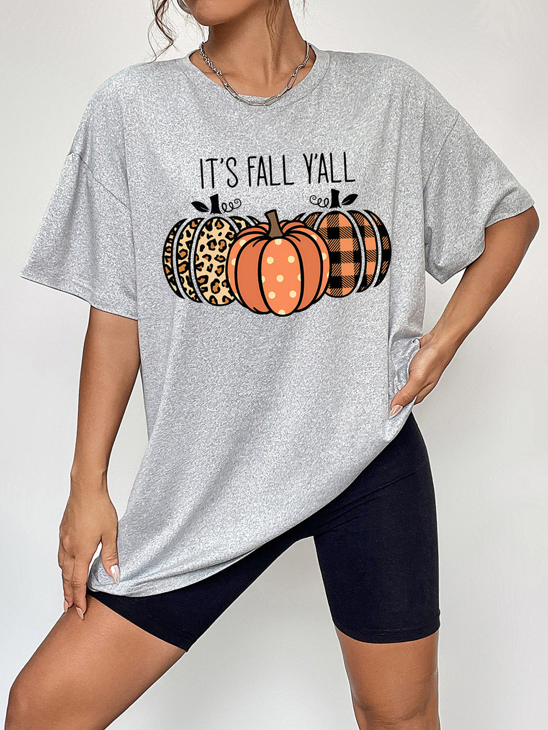 Gray graphic tee with "It's Fall Y'all" and three pumpkins in leopard, polka dot, and plaid patterns.