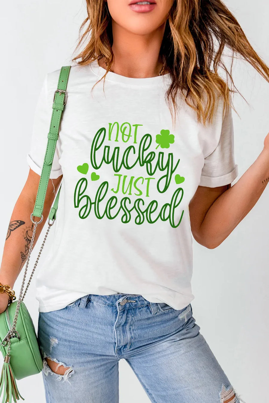 White t-shirt with green text that says Not Lucky Just Blessed and shamrock graphics.