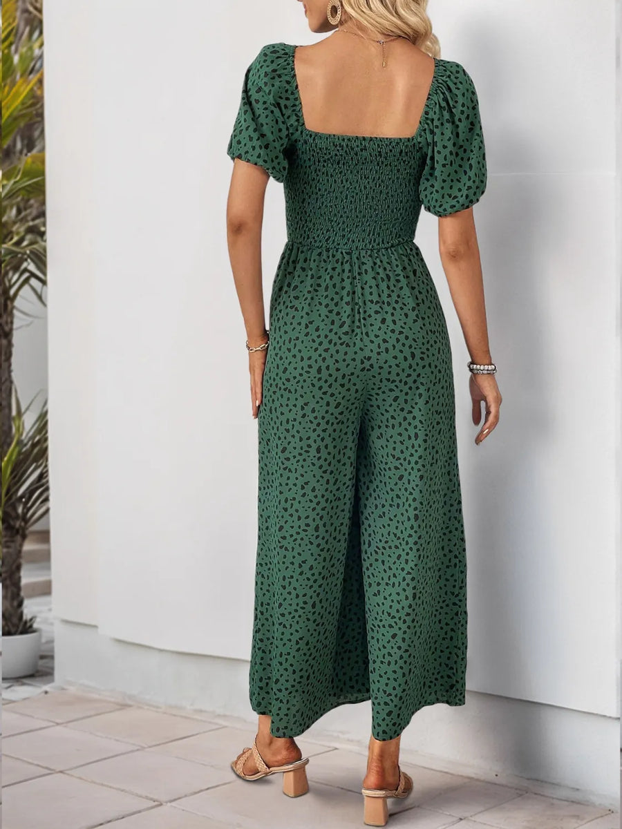 Dark green leopard print jumpsuit with smocked bodice and puff sleeves.