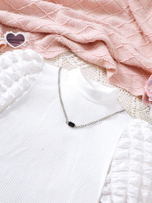 White ribbed puff sleeve top with chain detail and black accent