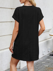 Black eyelet mini dress with diamond pattern, crew neck, short sleeves, and A-line cut.