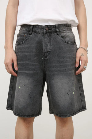 Dark wash denim bermuda shorts with artistic paint splatter detail