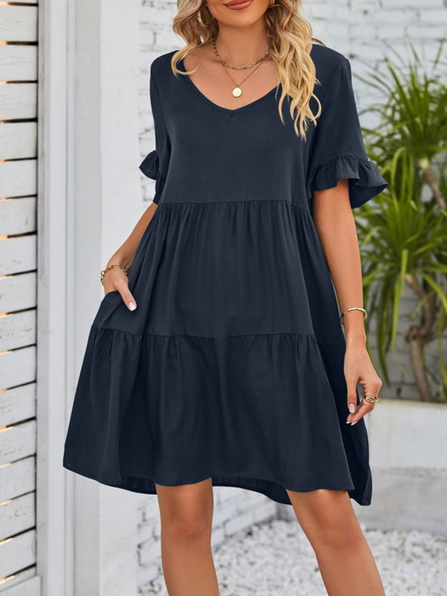 Navy ruffled sleeve mini dress with pockets and tiered skirt.