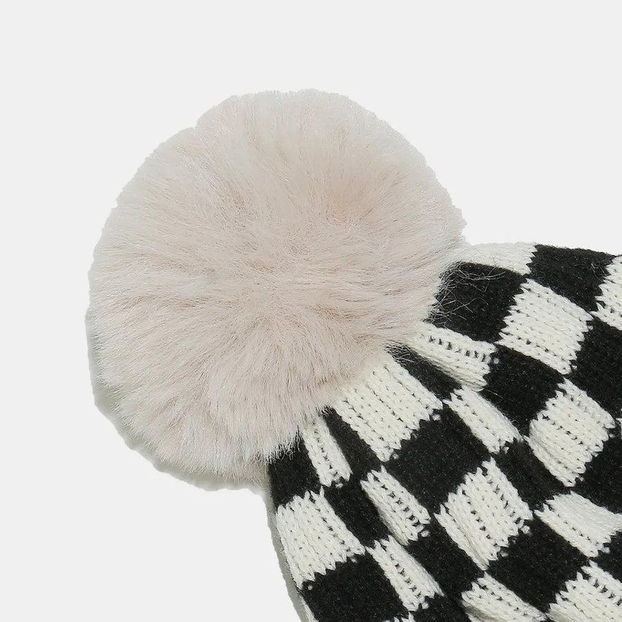 Checkerboard knit beanie with faux fur pom in black and white acrylic.