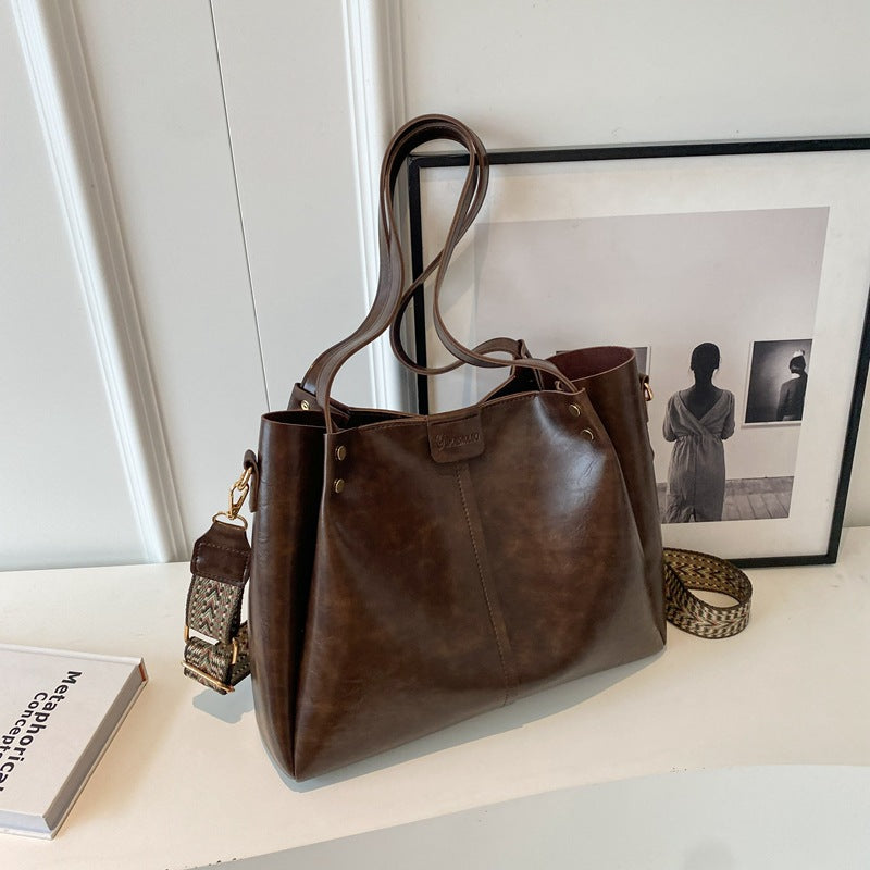 Large distressed brown leather shoulder bag with detachable patterned strap
