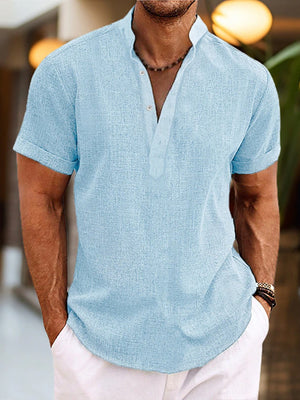 Men's light blue cotton blend short sleeve henley shirt with button placket.