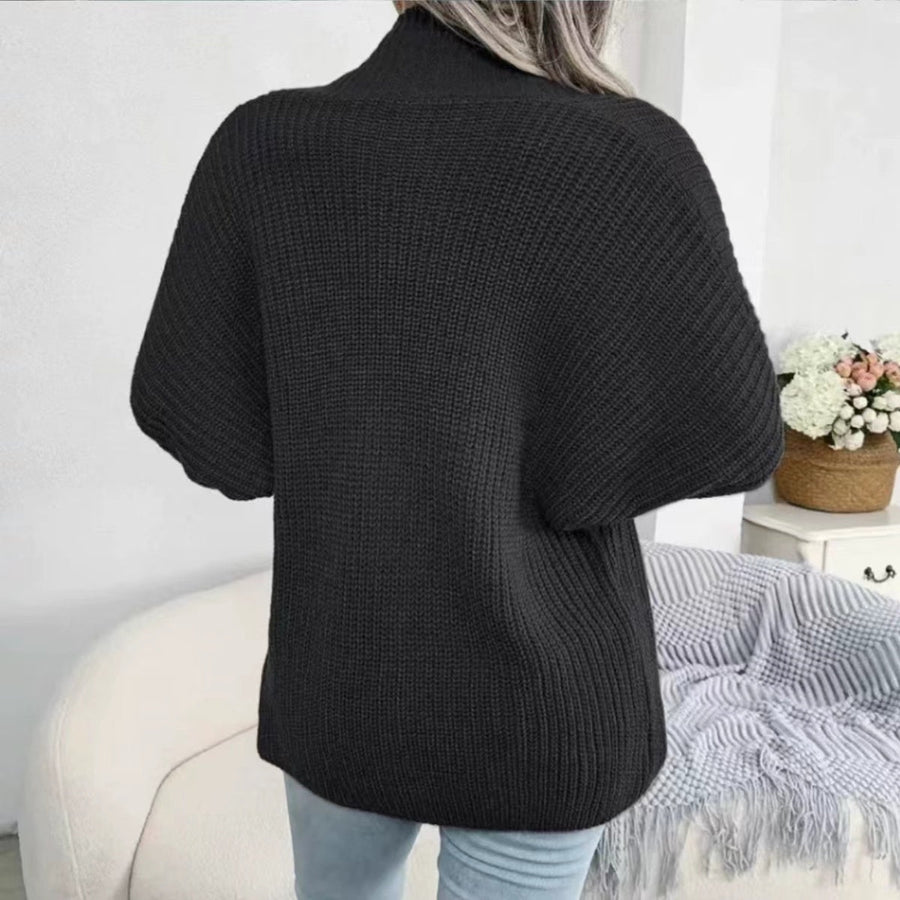 Black chunky knit dolman sleeve cardigan with a mock neck, shown from the back.