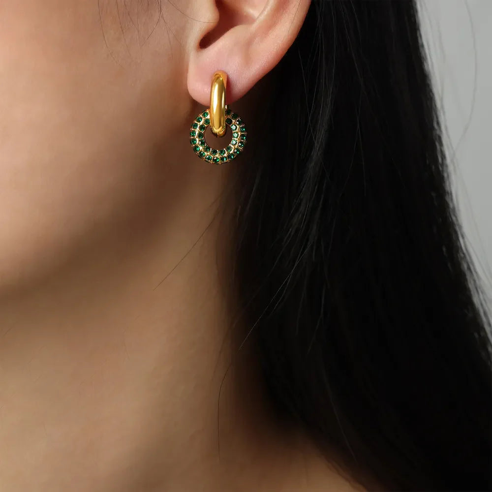 Gold hoop earrings with a dark green pavé circle interlock detail.