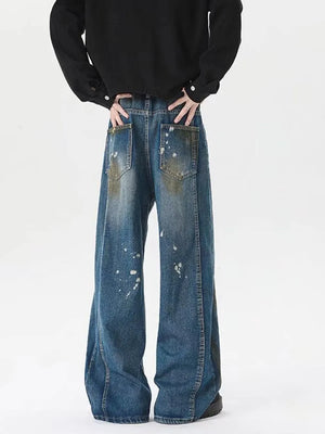 Men's plus-size wide-leg jeans in washed blue denim with paint splatters and distressed pockets.