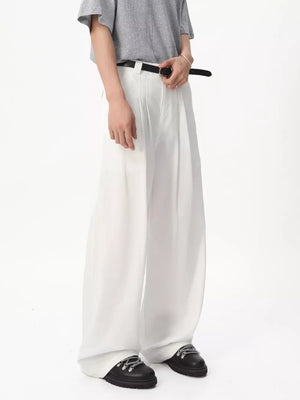 White relaxed wide-leg pleated sweatpants with a belt and black boots.