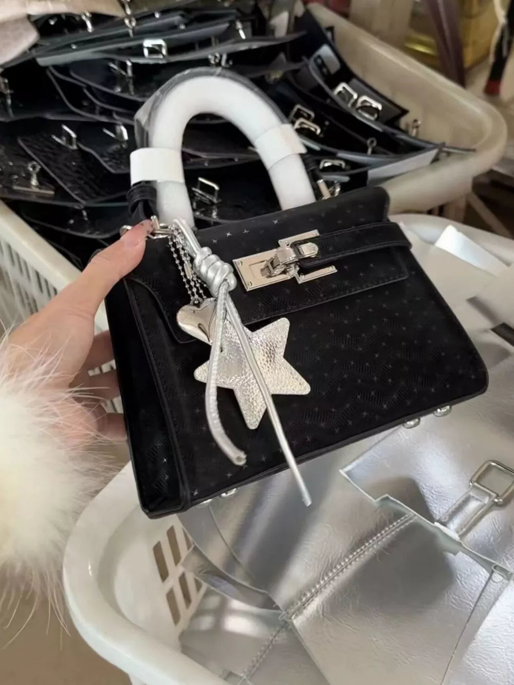 Black embossed mini handbag with star charm and silver hardware.