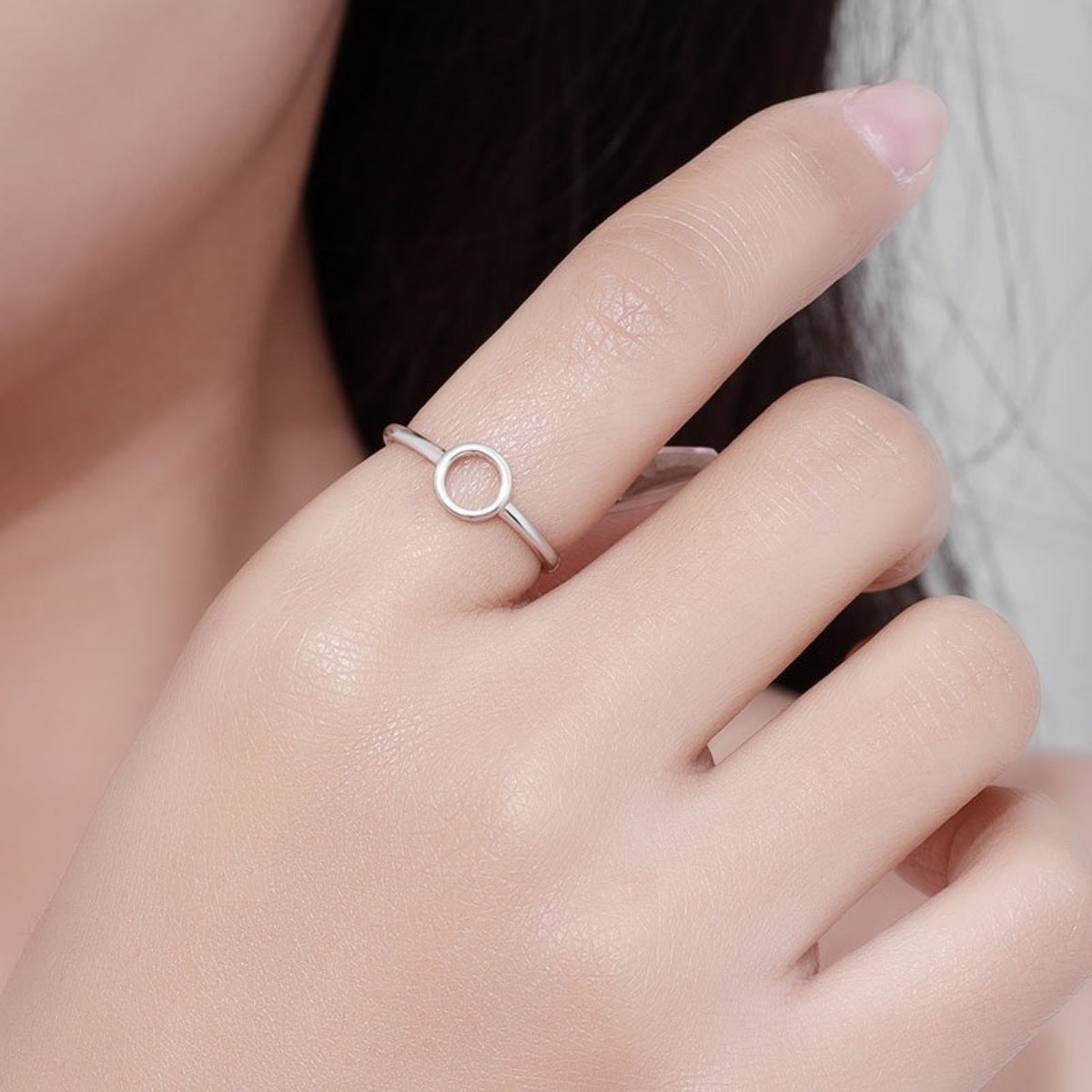 Sterling silver minimalist circle ring on a woman's finger.