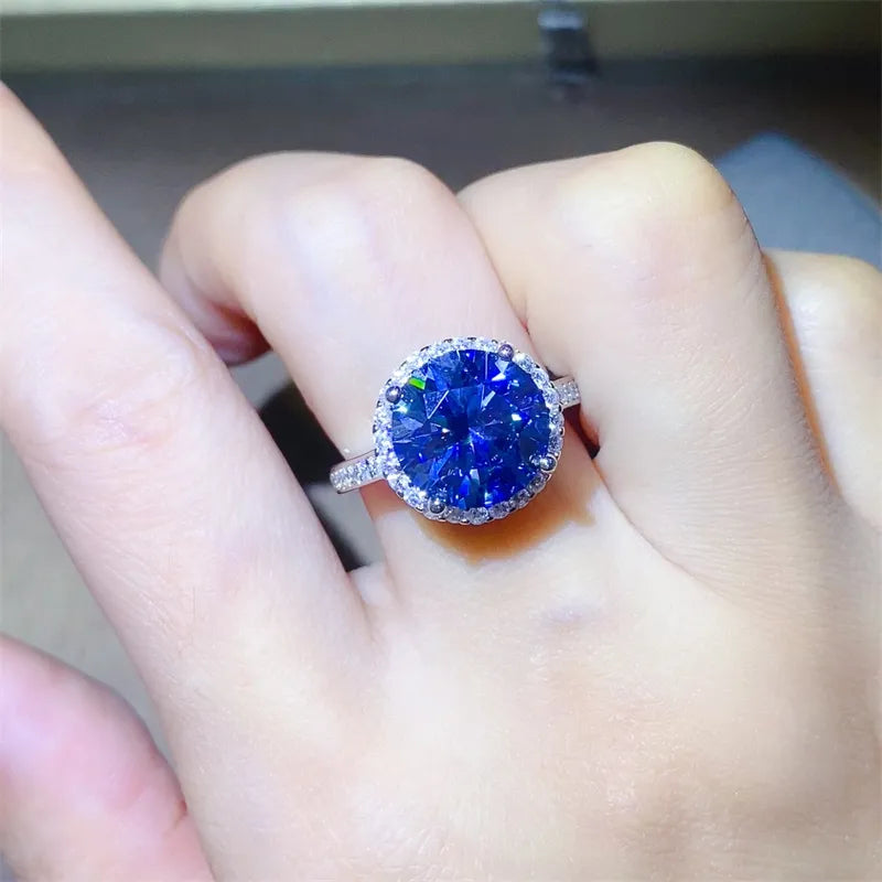 Silver halo cocktail ring with a large round blue sapphire and diamond accents.