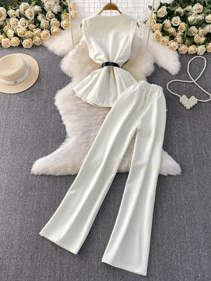 White belted two-piece set with wide leg pants and sleeveless top with pockets.