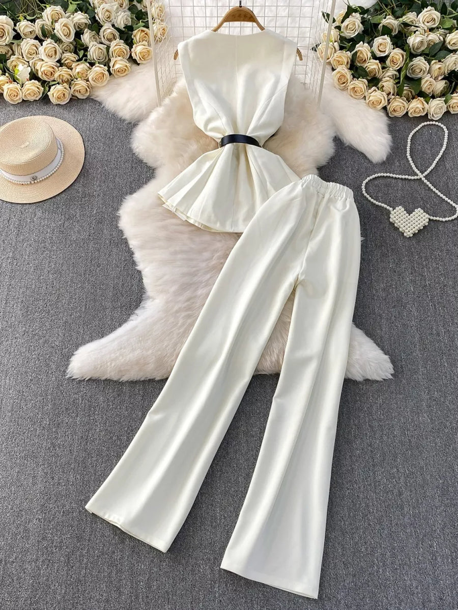 White belted two-piece set with wide leg pants and sleeveless top with pockets.