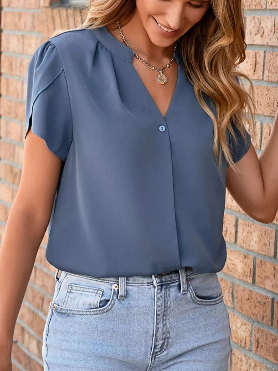 Blue V-neck blouse with petal sleeves and a single button detail.