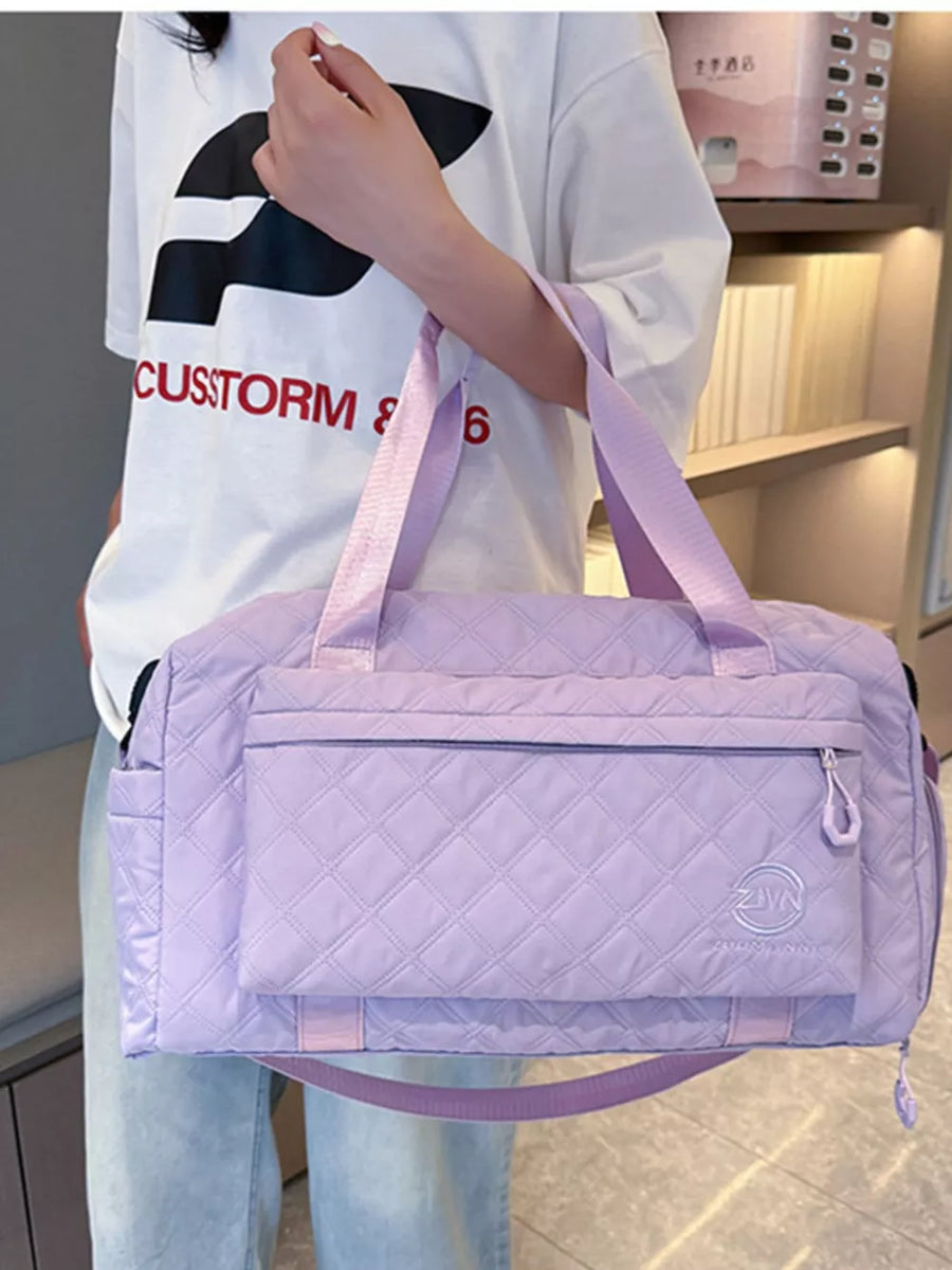 Diamond-quilted travel bag in Taro Purple with versatile straps and front zip pocket.