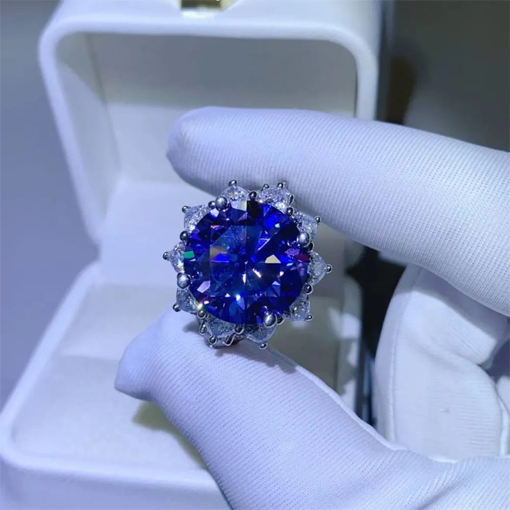 Dark blue moissanite cocktail ring in sterling silver with a halo of smaller stones.
