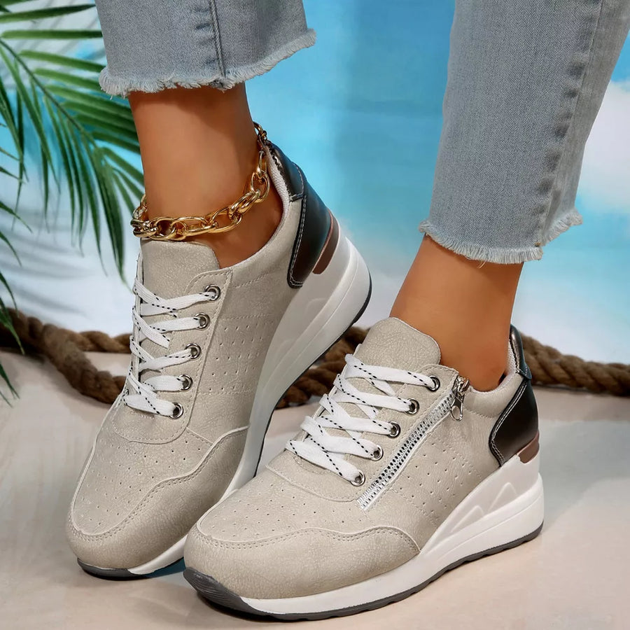 Beige lace-up wedge sneakers with side zipper detail and chunky heel.